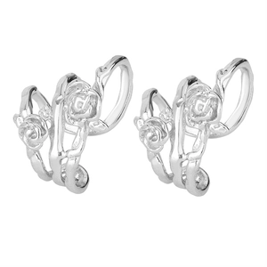 Detailed close-up of vintage silver rose thorn ear cuffs with intricate floral reliefs