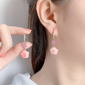 Detailed close-up of pink peach blossom drop earrings with silver pave hooks and petals