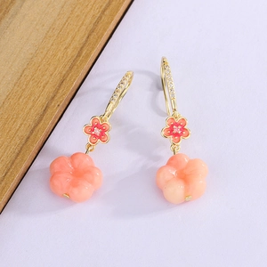 Detailed macro view of peach blossom earrings with gradient enamel petals and zircon hooks