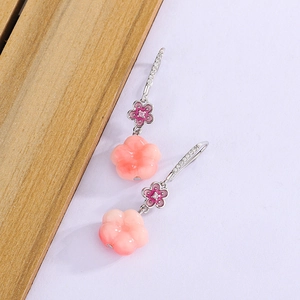 Detail of peach blossom earrings with pink gradient petals and crystal-set silver hooks