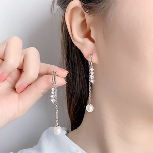 Long tassel earrings with zircon and pearls on a model for a slender elegant look