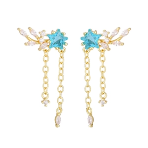 Detailed shot of golden star tassel earrings featuring blue stones and zircon fringes