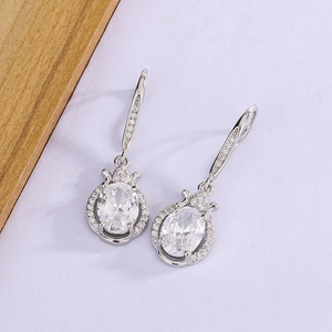 Detailed view of silver drop earrings with oval cubic zirconia and halo micro-pave setting