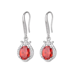 Close-up of tulip-shaped earrings with red oval zircon and silver-tone floral details
