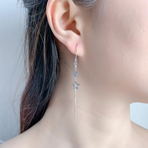 Nahaufnahme eleganter langer Stern-Ohrringe mit Quaste und Zirkonia am Modell