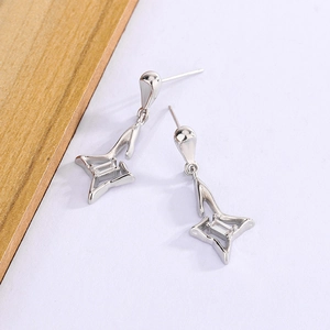 Détail de boucles d'oreilles étoile en argent avec zircon rectangulaire et fini lisse