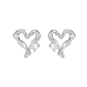 Detailed view of hollow heart earrings with irregular silver metal and sparkling zircons