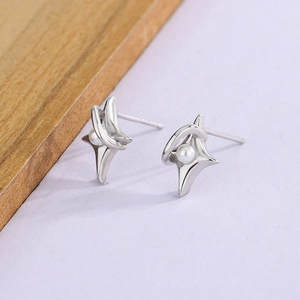 Minimalist S925 silver star stud earrings with pearl accent on a textured background