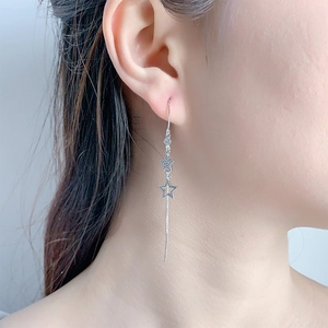 Elegante lange Stern-Quasten-Ohrringe mit Zirkonia-Inlay an einem Model-Seitenprofil