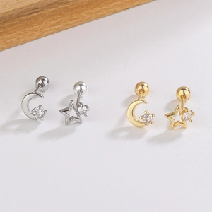 Detail view of gold and silver asymmetric star and moon stud earrings with zircon stones