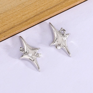 Elegant star earrings with pearls and zircon on a soft lavender and wood background