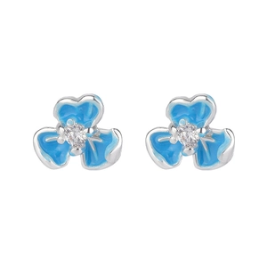 Macro detail of blue iris flower earrings with bright enamel petals and central zircon