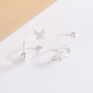 Macro shot of silver spiral ear studs with polished butterfly and bead details