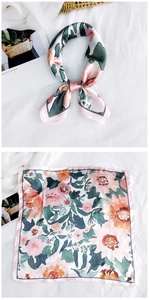 Detail of floral printed silk square scarf with neat hem and artistic peach green pattern