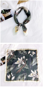 Detail of silk square scarf with dark green lily floral print and yellow hem contrast