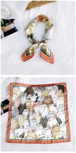 Detailed view of square silk scarf with cute cartoon cat prints and colorful border