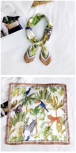 Detailed macro view of tropical rainforest print silk scarf with animal and leaf patterns