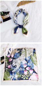 Detail of tropical rainforest silk scarf with leopard print and floral pattern on white fabric