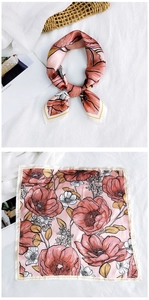 Detailed macro view of silk square scarf featuring floral patterns and yellow hem stitching