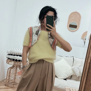 Pale yellow mohair sweater paired with a cat-print silk scarf and brown trousers