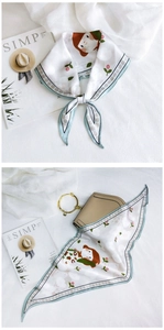 Detail of floral cartoon pattern scarf tied on hand and as handbag accessory decoration