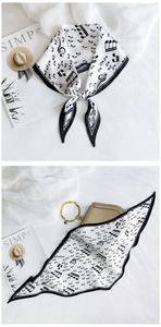 Detail of silk scarf with music notes tied on a light brown leather handbag handle