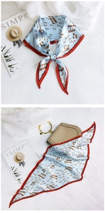 Detail of light blue silk scarf with musical note pattern and red contrast edge