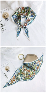 Detail of paisley floral silk scarf styled as an elegant handbag accessory and necktie