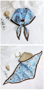 Detail of floral diamond scarf with light blue print and contrast brown hem edge