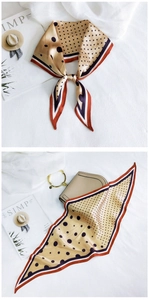 Close-up of khaki polka dot silk scarf tied on a handbag with chic French aesthetic