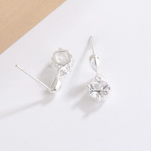 Close-up of four-prong square zircon drop earrings featuring polished silver plating