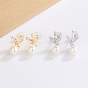 Detailed view of elegant butterfly leaf stud earrings with white pearls in gold and silver