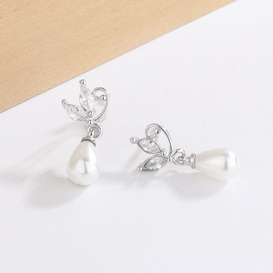 Detail of silver drop pearl earrings with leaf-shaped zircon stones in French style