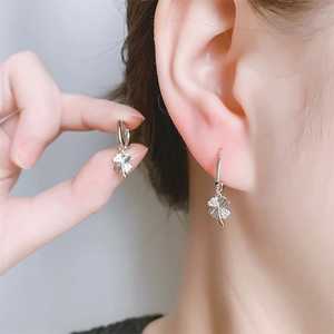 Détail de boucles d'oreilles trèfle à quatre feuilles avec pavé et nacre raffinée