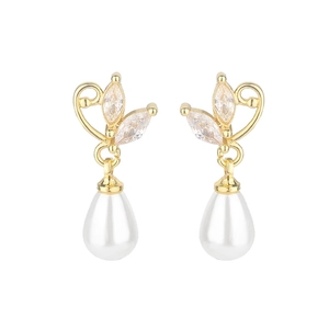 Detailed macro view of teardrop pearl earrings with gold-plated heart and zircon accents