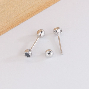 Macro detail of geometric stud earring with black gemstone and secure screw-back closure