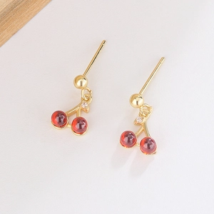 Macro detail of cherry stud earrings with red glass beads and small zircon leaves