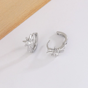 Detail of silver eight-pointed star hoop earrings with sparkling zircon centers