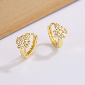 Macro detail of gold-plated clover earrings featuring pavé cubic zirconia setting