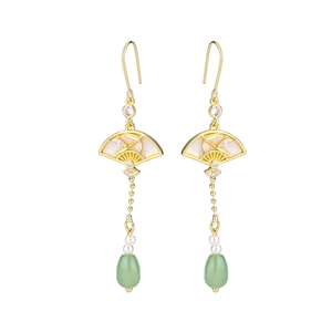 Détail de boucles d'oreilles éventail avec motifs bambou, perles et gouttes vertes