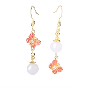 Détail de boucles d'oreilles papillon vintage asymétriques avec émail et perles