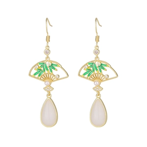 Détail de boucle d'oreille en éventail avec feuilles de bambou et goutte blanche