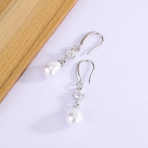 Detail of silver drop earrings with white teardrop pearls and clear round zircon crystals