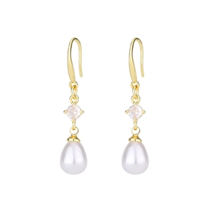 Close-up of elegant gold dangle earrings with sparkling zircon and teardrop pearls