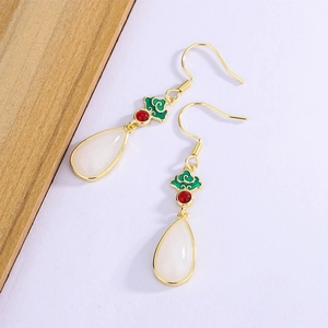 Detailed shot of emerald enamel ruyi pattern earrings with white waterdrop pendants