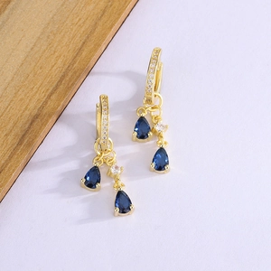 Elegant gold drop earrings featuring teardrop blue sapphires and sparkling white zircons