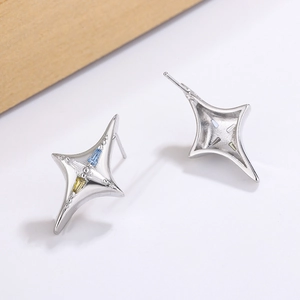 Vue macro de boucles d'oreilles étoile à quatre branches en argent et zircons colorés