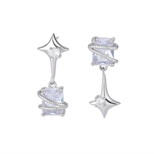 Détails macro des boucles d'oreilles asymétriques étoile et zircon argenté