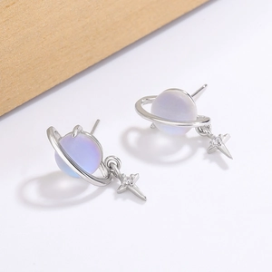 Macro shot of planet-themed earrings with iridescent purple beads and star charms