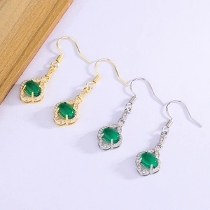 Macro detail of vintage teardrop earrings with green stones and zircon fringe